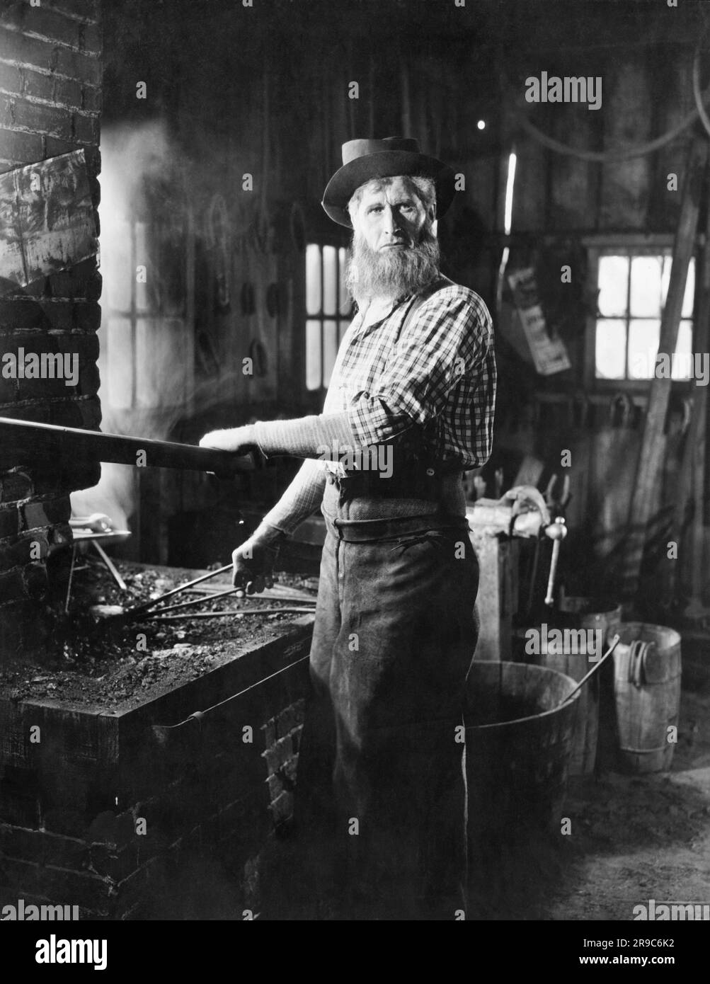 Open Forge United States: c. 1910 A blacksmith working at his forge Stock Photo ...