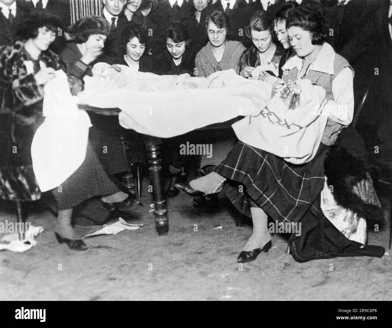 New York, New York:  January 23, 1919. Garment workers who are on strike for a 44 hour work week, gather together to sew to pass the time. Stock Photo