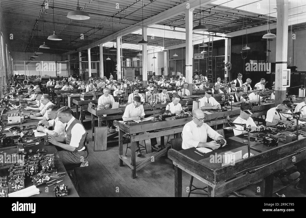 Rochester, New York:  c. 1923 Workers assembling Cine-Kodaks at the Camera Works at the Eastman Kodak Company. It was the first 16mm camera. Stock Photo