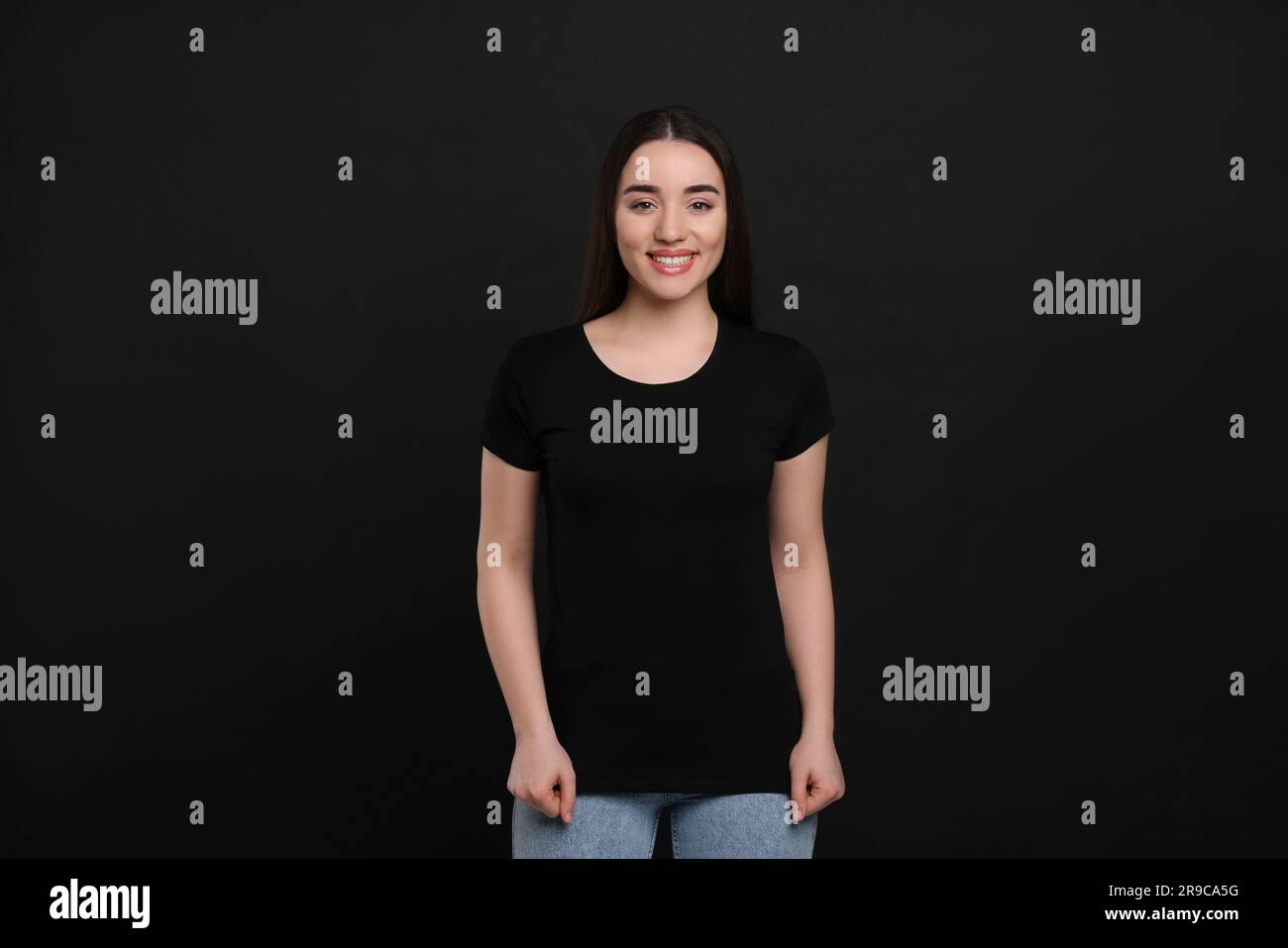 Woman wearing black t-shirt on dark background Stock Photo - Alamy