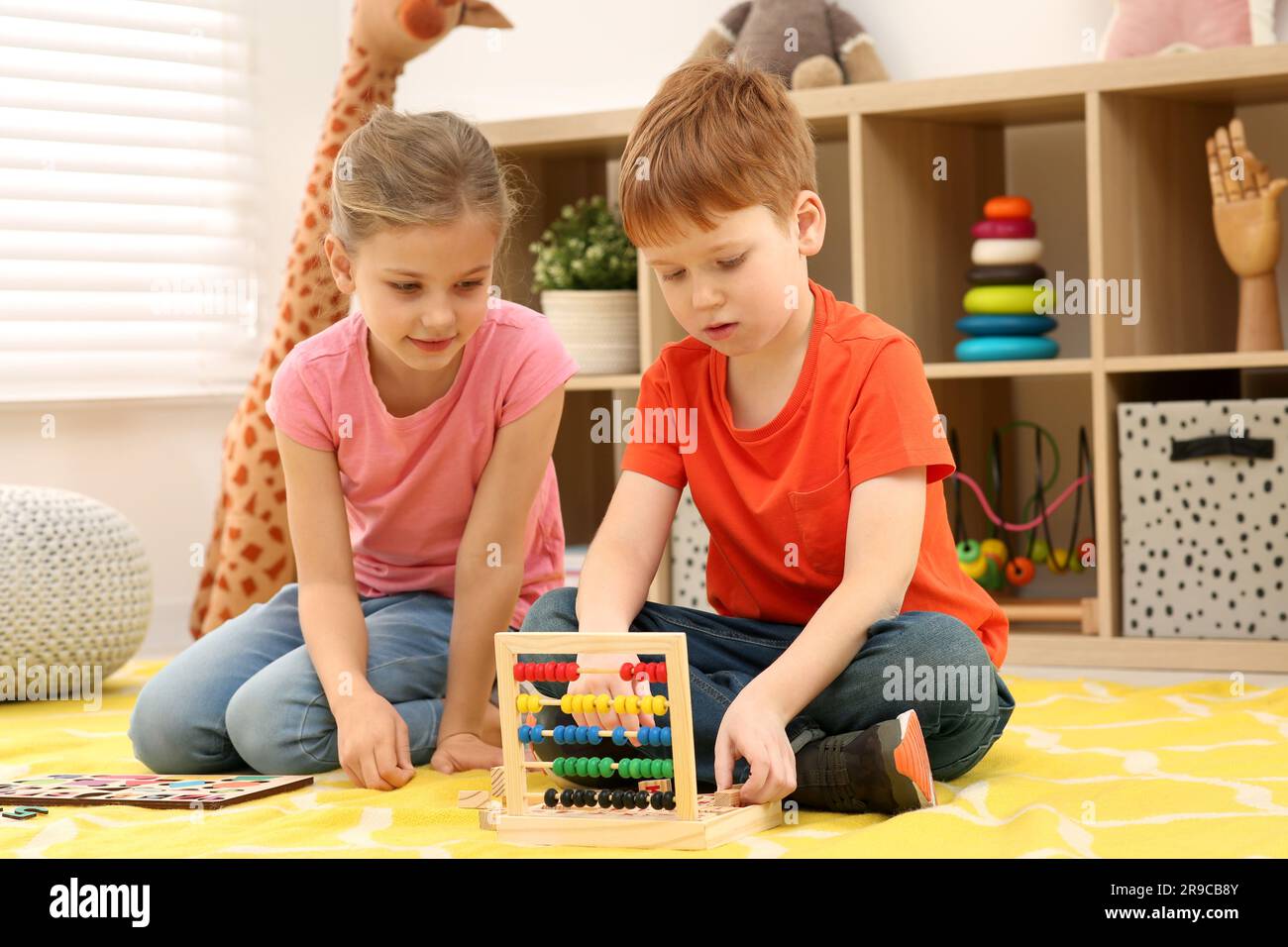 Children playing with math game kit on floor in room. Learning