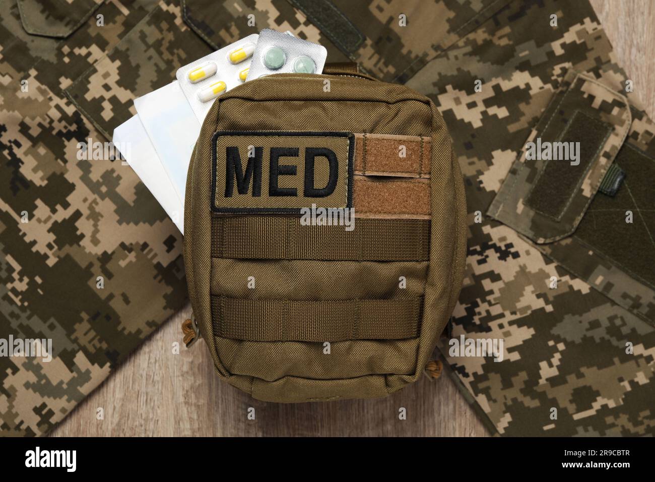 First aid kit and military uniform on wooden table, flat lay Stock ...