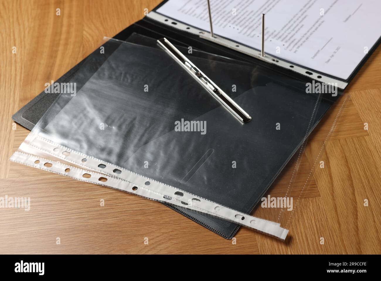 File folder with punched pockets on wooden table, closeup Stock Photo