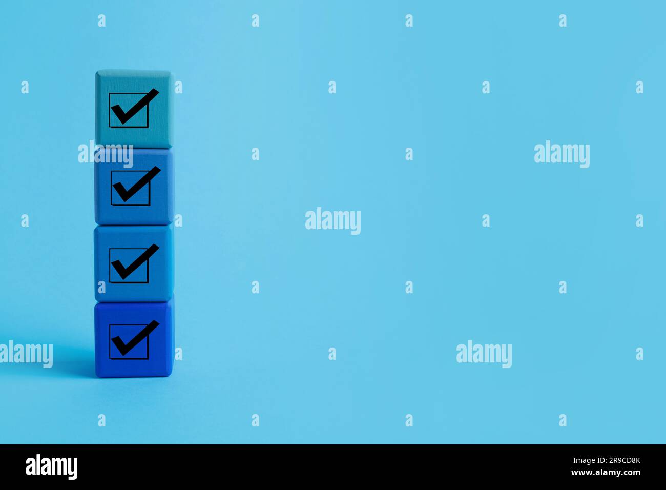 Stacked cubes with check marks on light blue background. Space for text ...