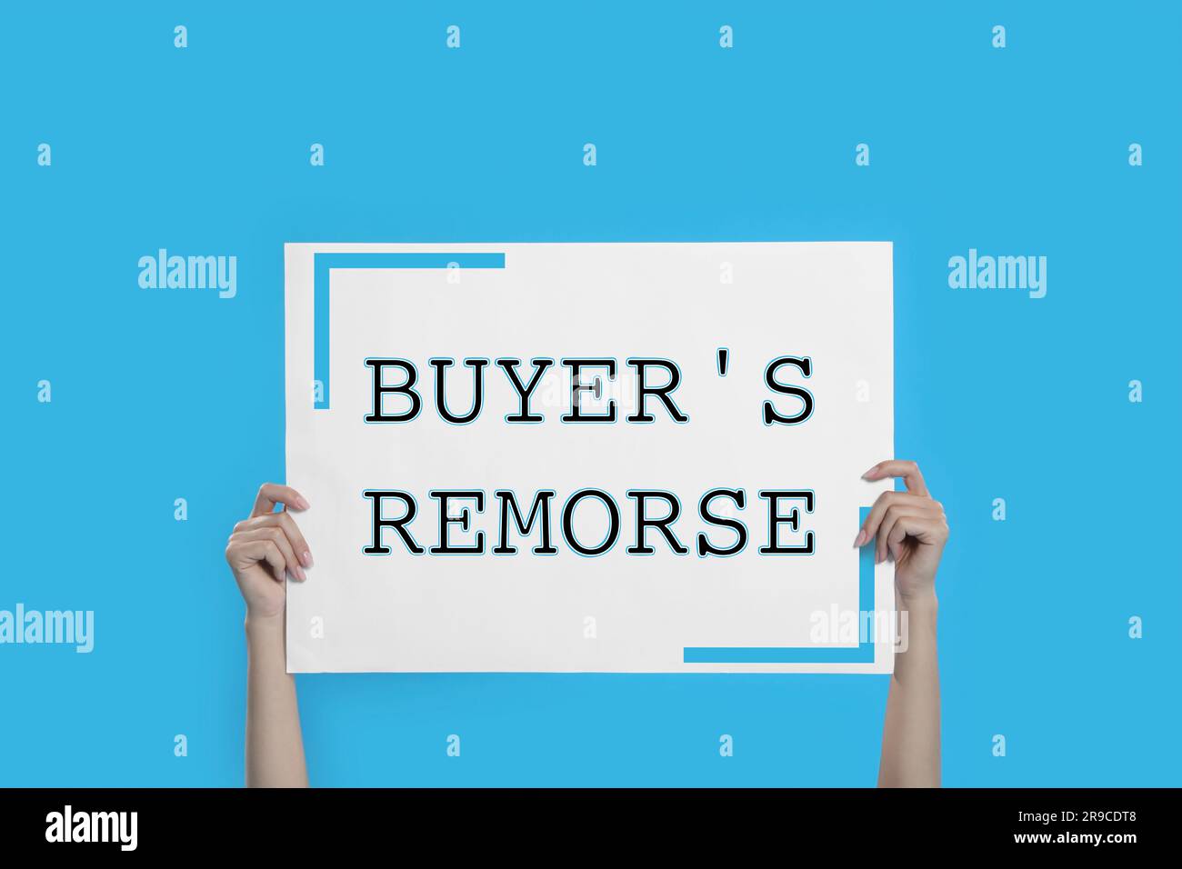 Woman holding poster with text Buyer's Remorse on light blue background, closeup Stock Photo