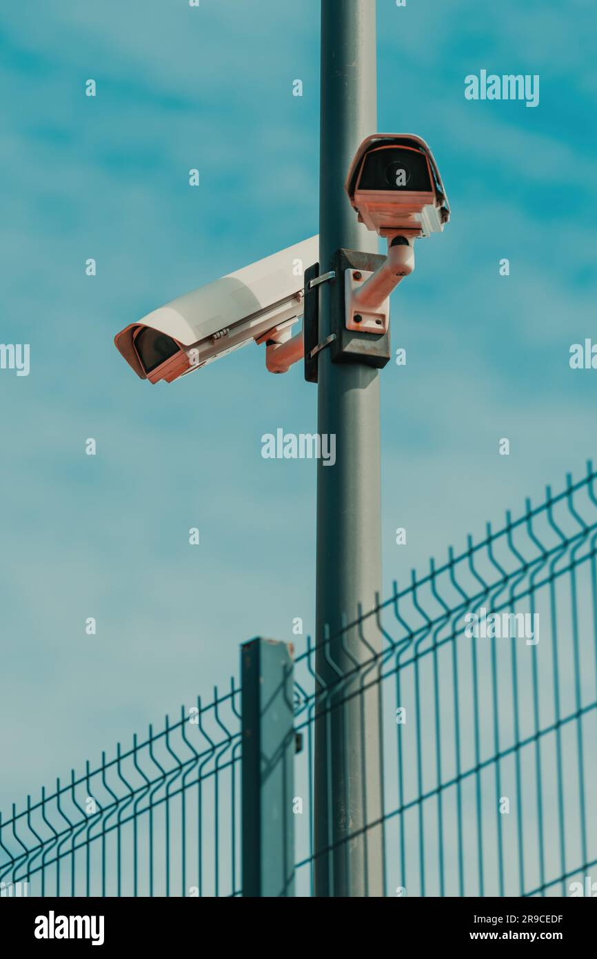 Prison yard surveillance security cameras mounted on the post, selective focus Stock Photo