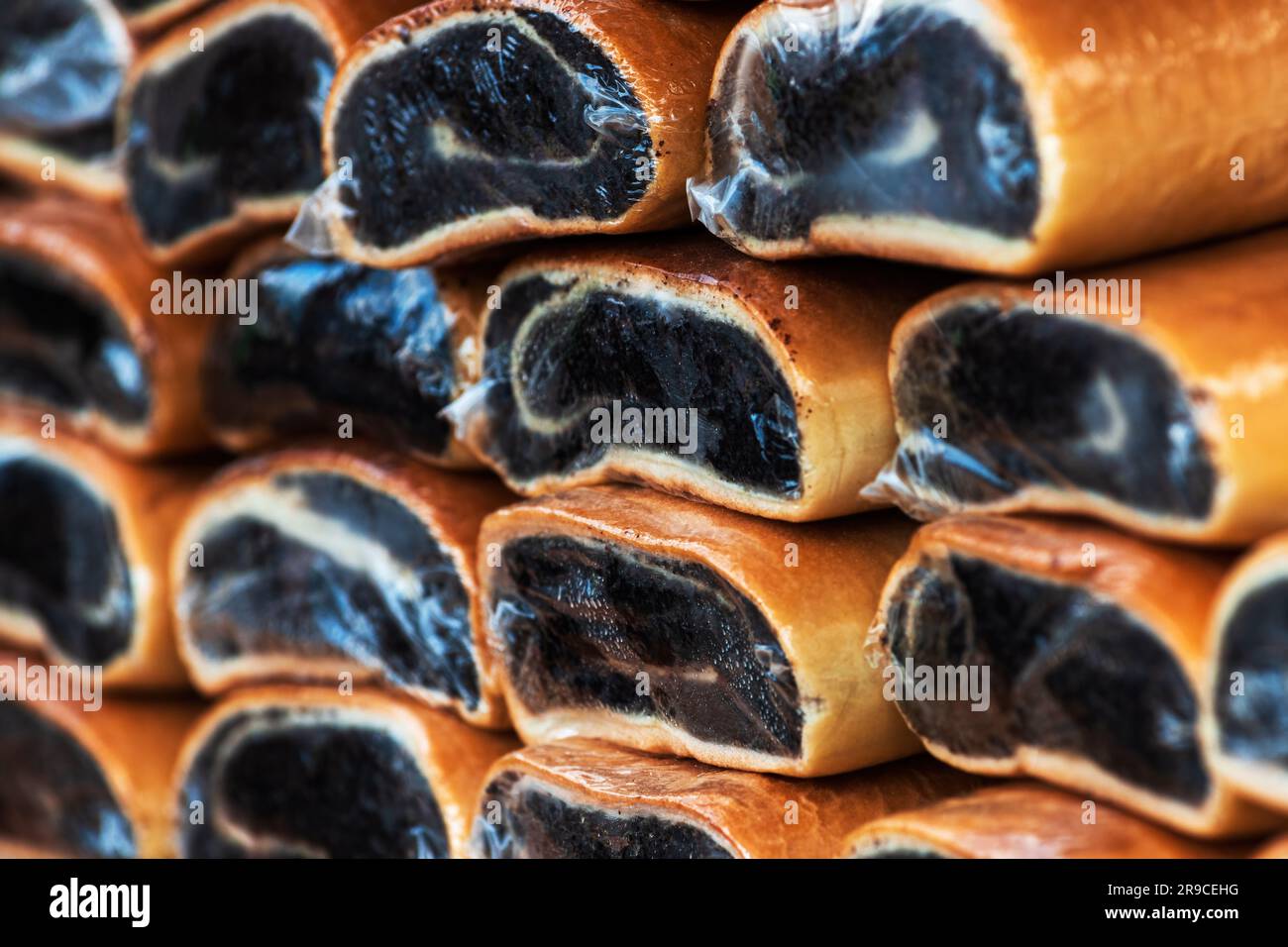 Poppy seed roll cake also known as strudel wrapped in plastic on outdoor street market, selective focus Stock Photo