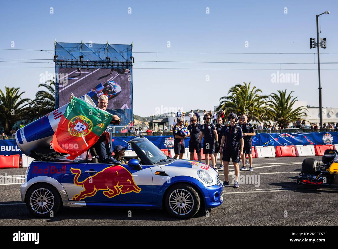 Lisbon, Portugal. 25th June, 2023. Briton David Coulthard holds a Portuguese flag as he greets spectators during the first edition of the Red Bull Showrun. Credit: SOPA Images Limited/Alamy Live News Stock Photo