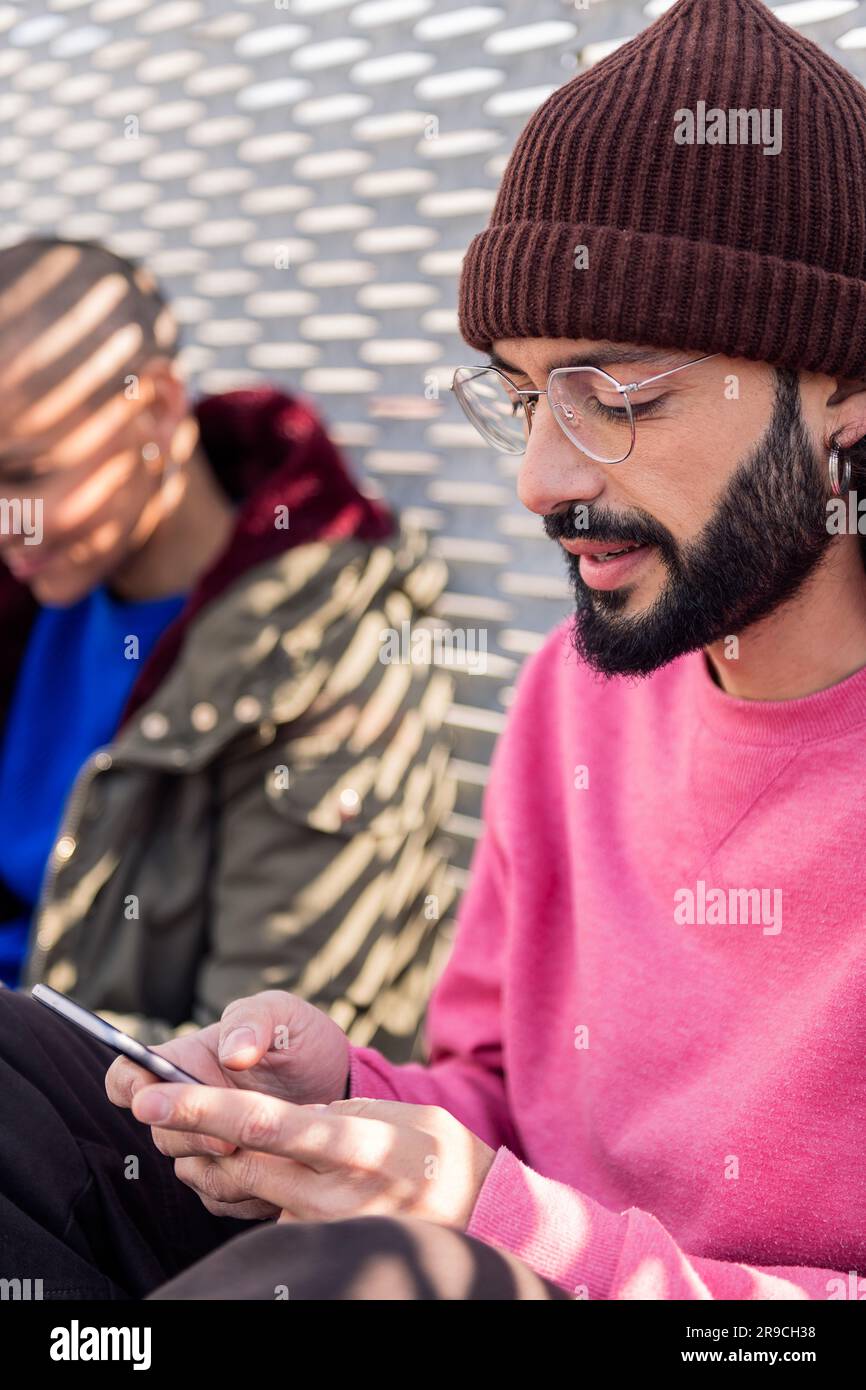 young man using mobile phone with friends Stock Photo