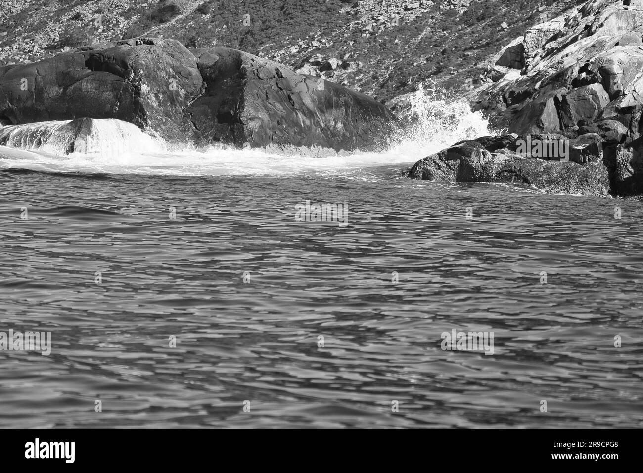 Norway on the fjord, spray on rocks in black and white. Water splashing on the rocks. Coastal landscape in Scandinavia. Landscape photo from the north Stock Photo