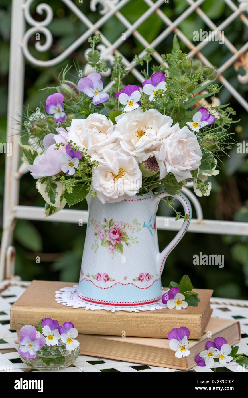 bouquet of white roses, viola flowers, devil-in-the-bush and lady's mantle in milk can Stock Photo