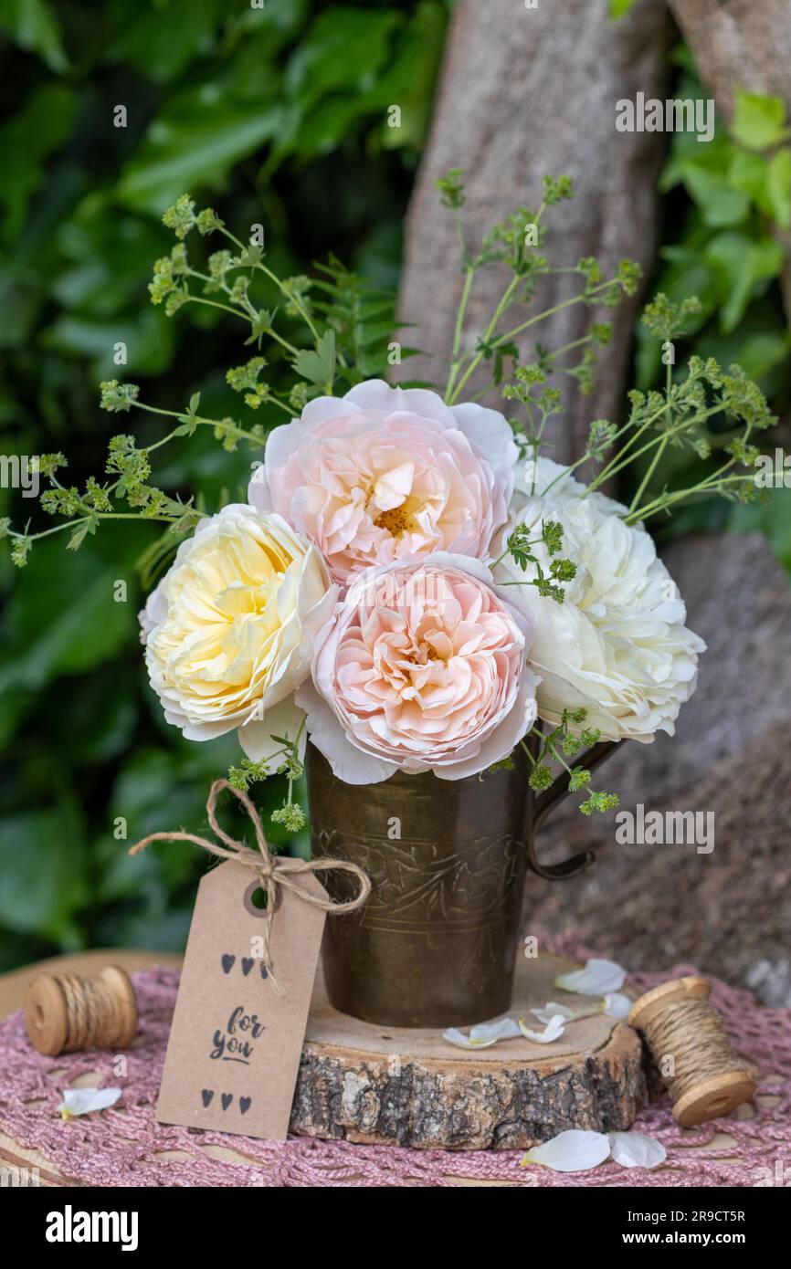 bouquet of english roses in old copper cup in garden Stock Photo