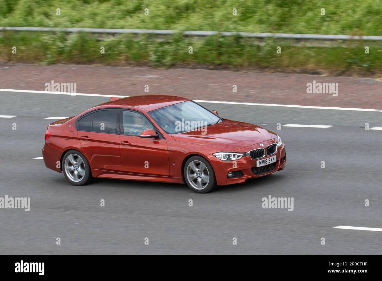 2018 Red BMW 330E M Sport Auto travelling at speed on the M6 motorway in Greater Manchester, UK Stock Photo