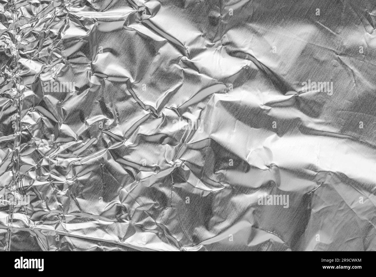 Crumpled bright shiny metallic silver aluminium foil background, flat lay view backdrop with copy space for text Stock Photo