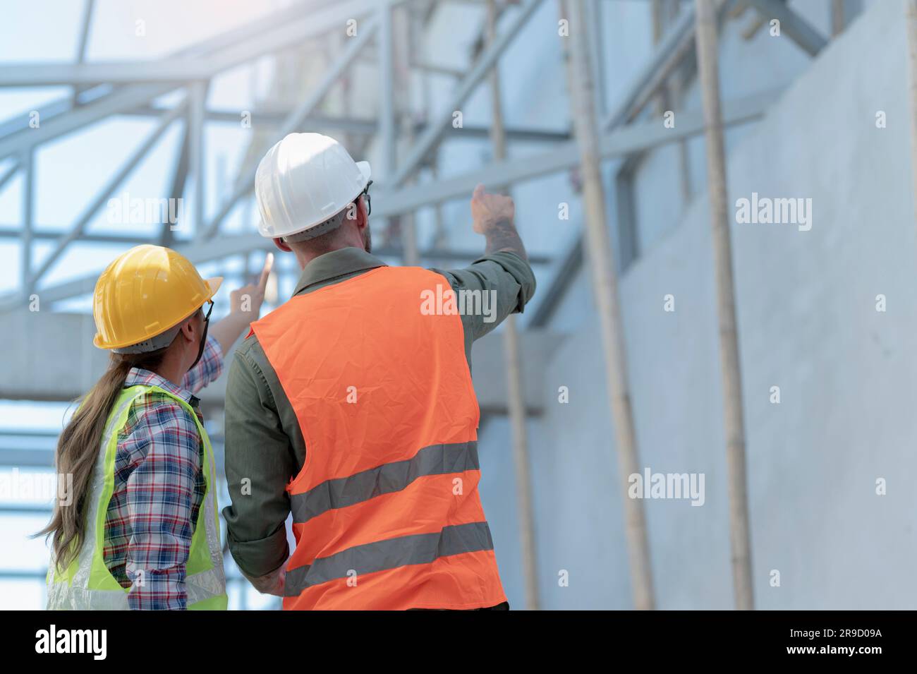 A young man and woman in safety helmets inspecting new buildings Stock ...