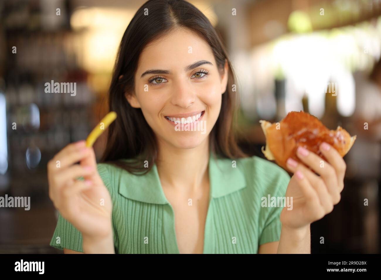 Happy restaurant customer holding potato and sandwich looking at you ...