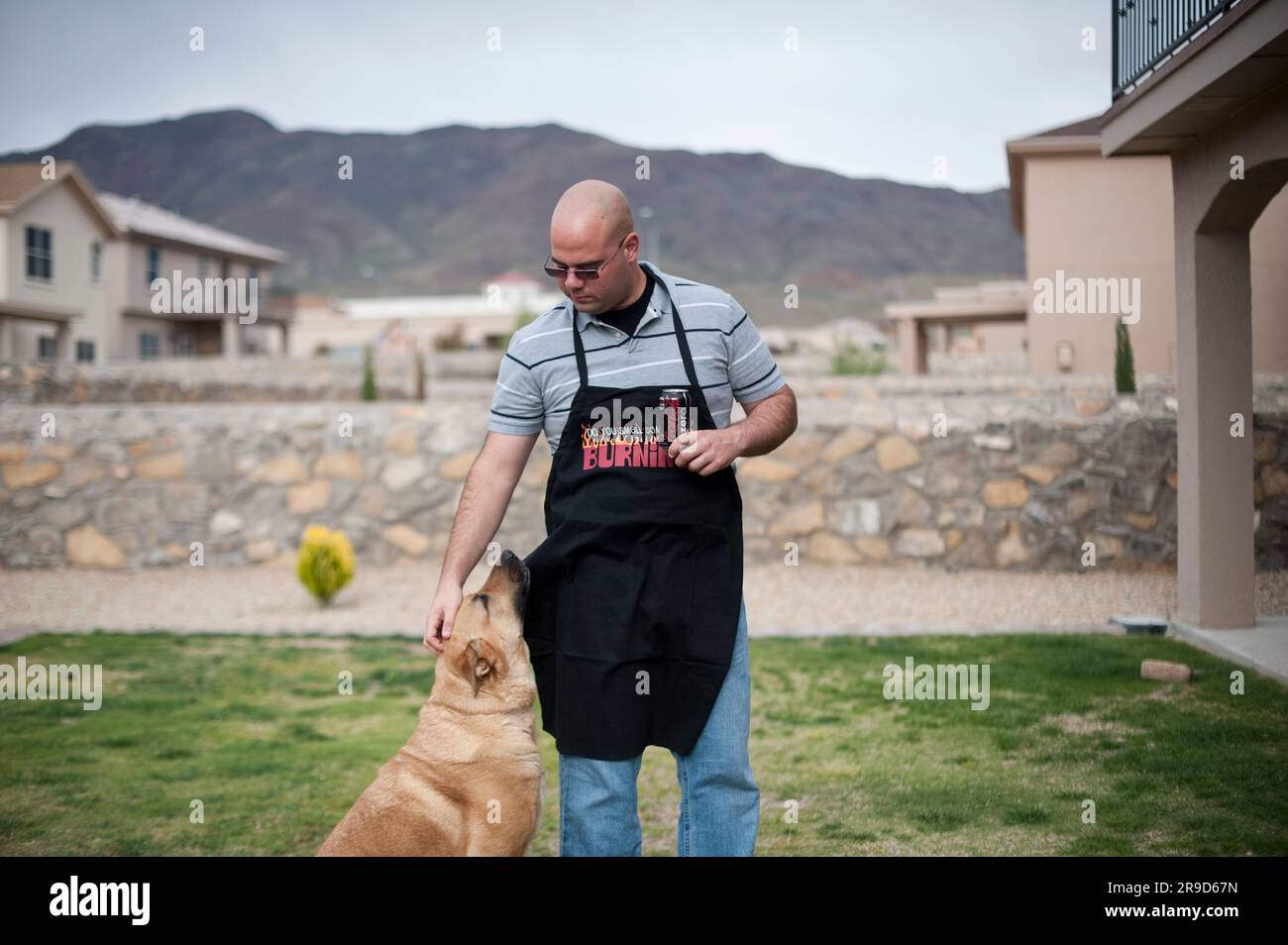 Iraq War Veteran relaxes with his dog while cooking. Stock Photo