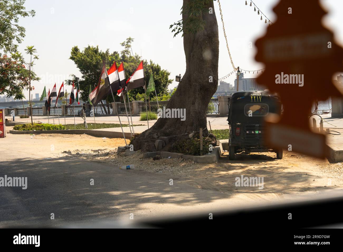 Cairo, Egypt - June 25 2023: Egyptian flags and Tuktuk seen from a vehicle parked next to the new 'Ahl Misr Walkway' by the Nile Stock Photo
