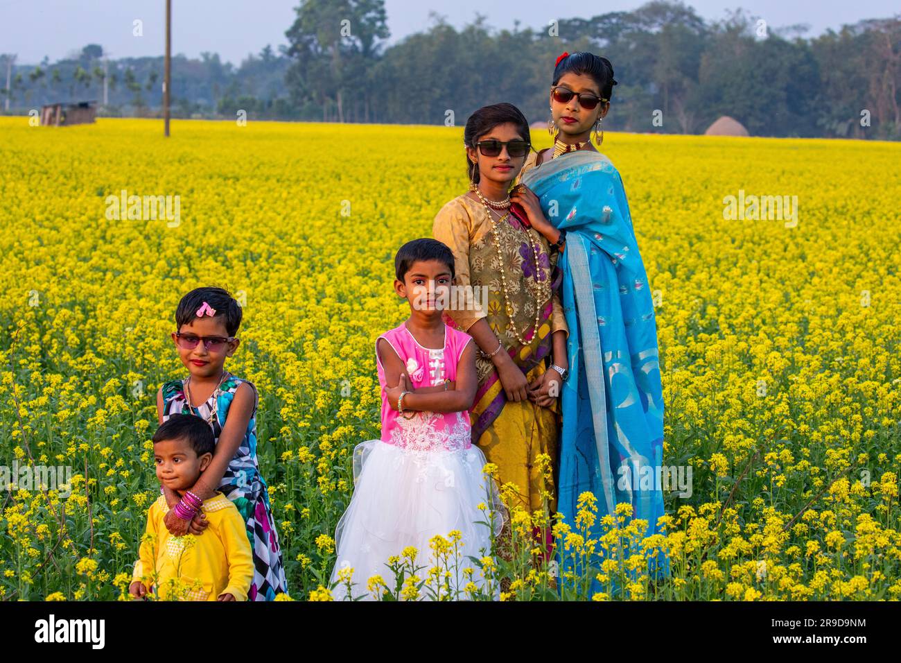Bangladeshi rural adolescent girls and children inside a mustard field at Singair in Manikganj, Bangladesh. Stock Photo