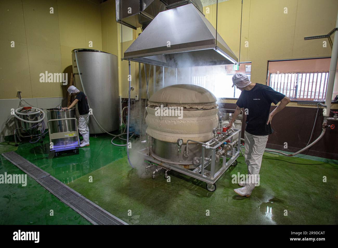 Producing Japanese sake :Brewer at Akashi Sake Brewery ,steaming rice for sake ,Hyogo prefecture, Japan. Stock Photo