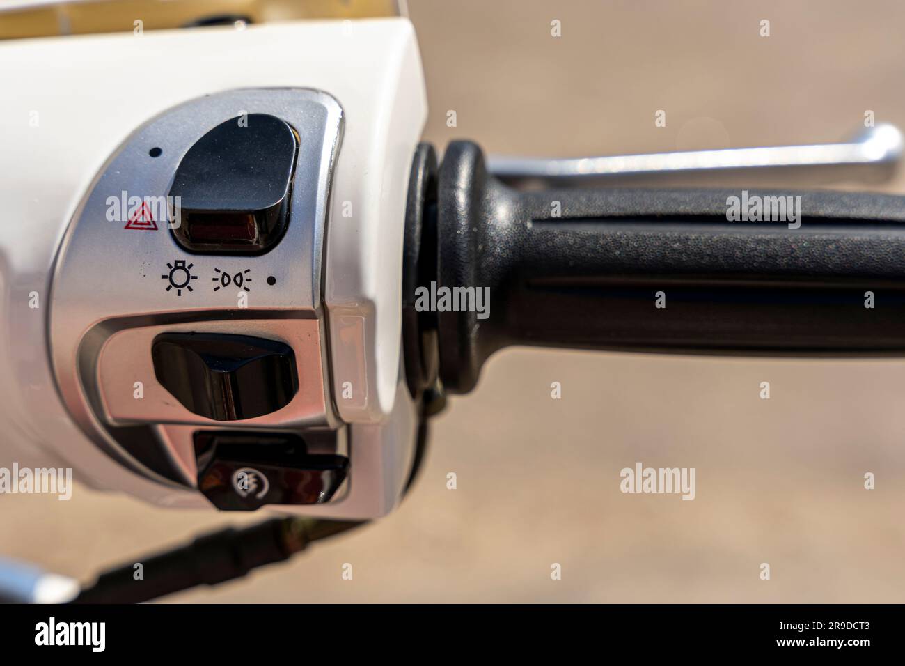 The throttle control knob and lighting fixtures on the handlebars of