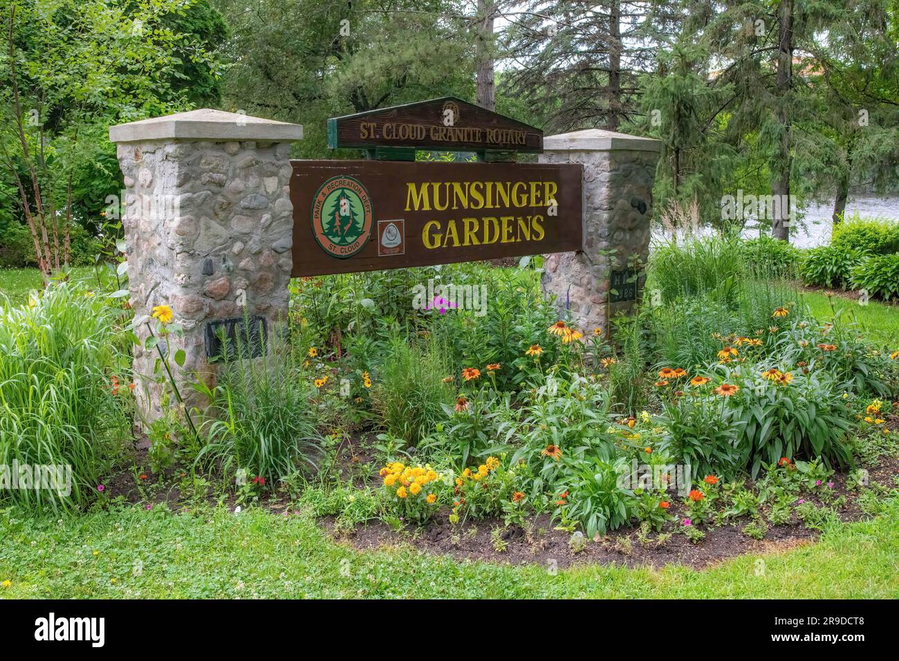 Entrance sign to Munsinger Gardens on the Mississippi River with a flowerbed of yellow