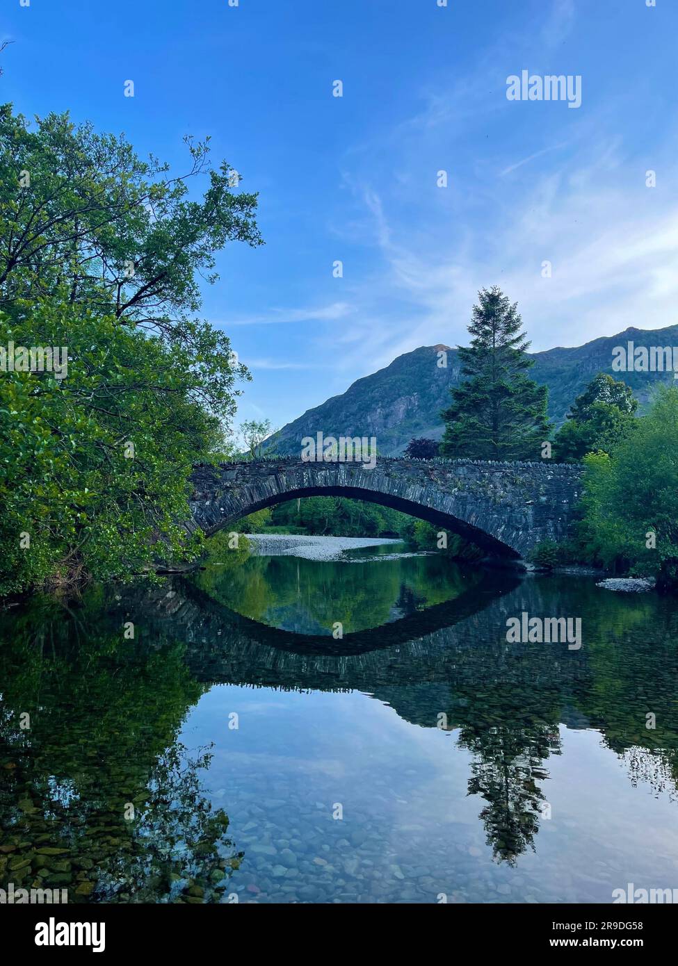 A scenic view of a bridge spanning a body of water surrounded by lush ...