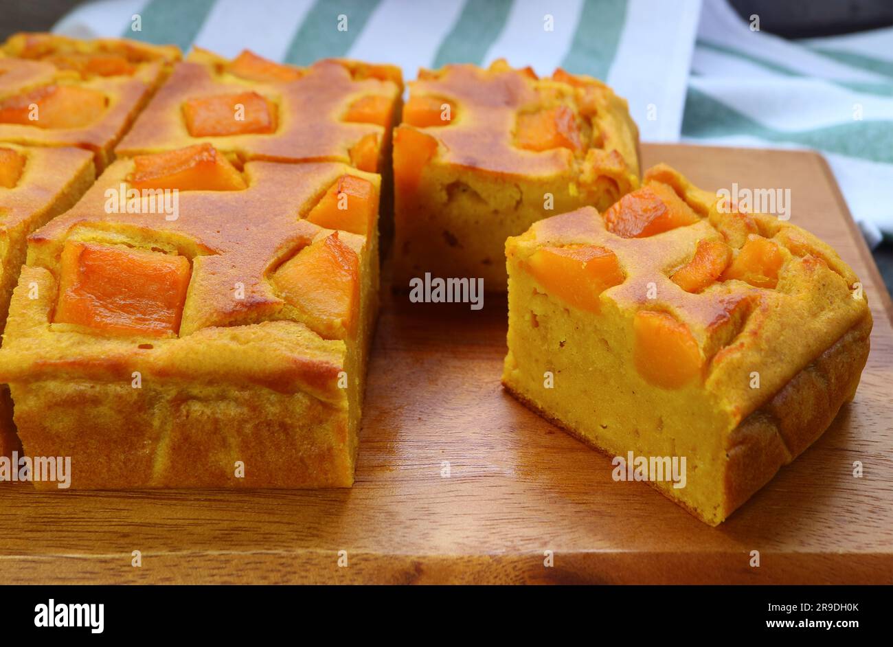 Delectable Freshly Baked Homemade Pumpkin Cake on Wooden Breadboard Stock Photo