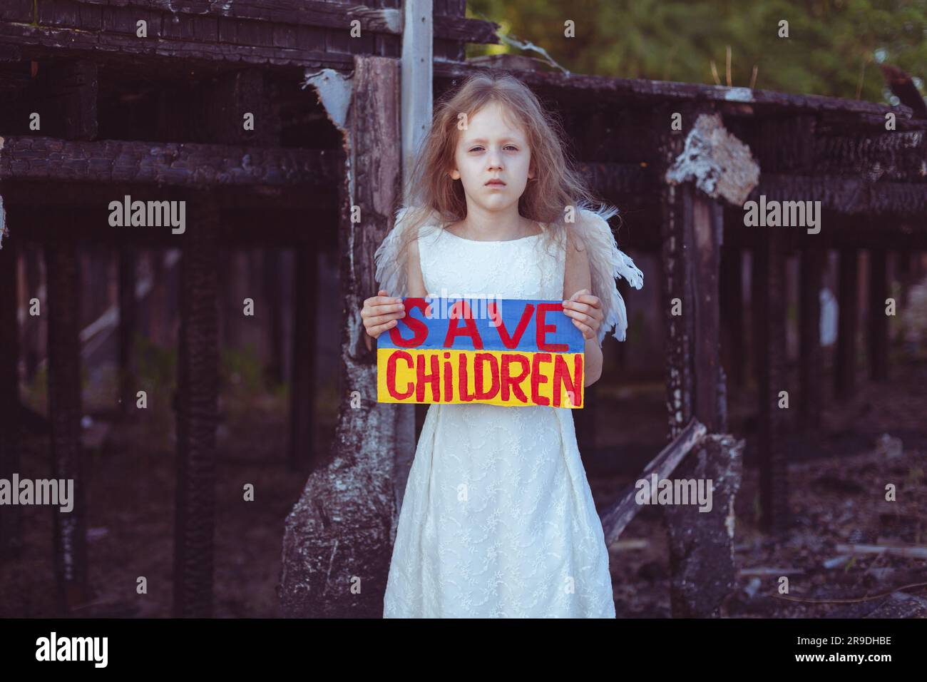 A girl with a poster in her hands asks to protect children. It is ...