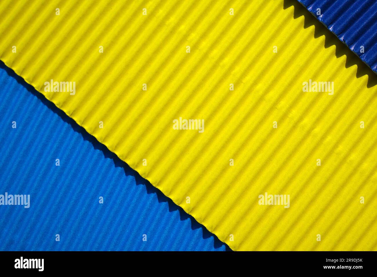 Diagonally ribbed cardboard with the colors blue, yellow, indigo. Meant as background Stock Photo