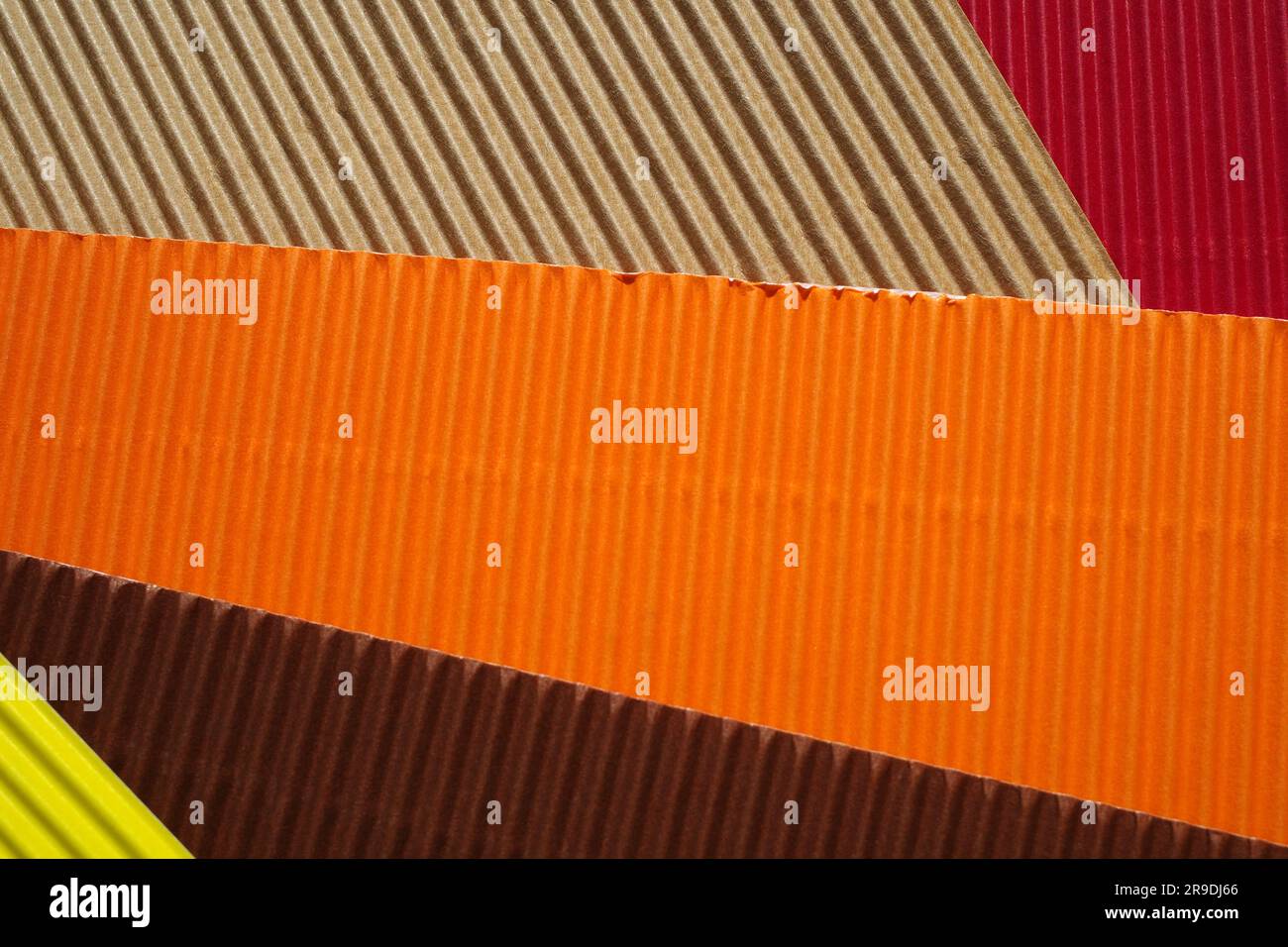 Diagonally ribbed cardboard with the colors beige, red, orange, brown and yellow. Meant as background Stock Photo