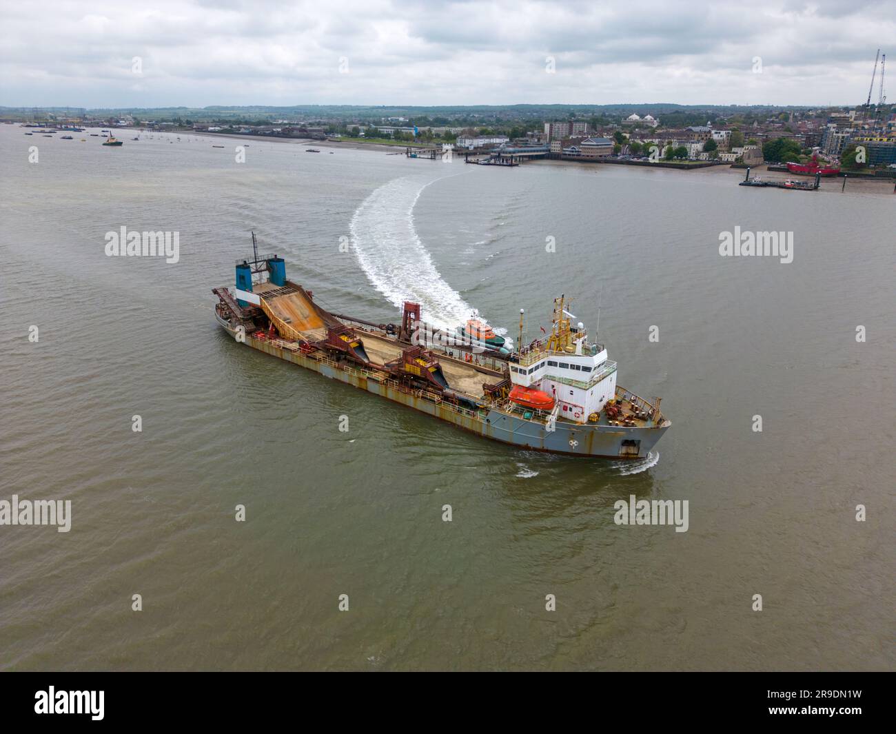 Aerial drone photo of a large freight ship which sails on the river Thames and the Tilbury Docks in England. Stock Photo