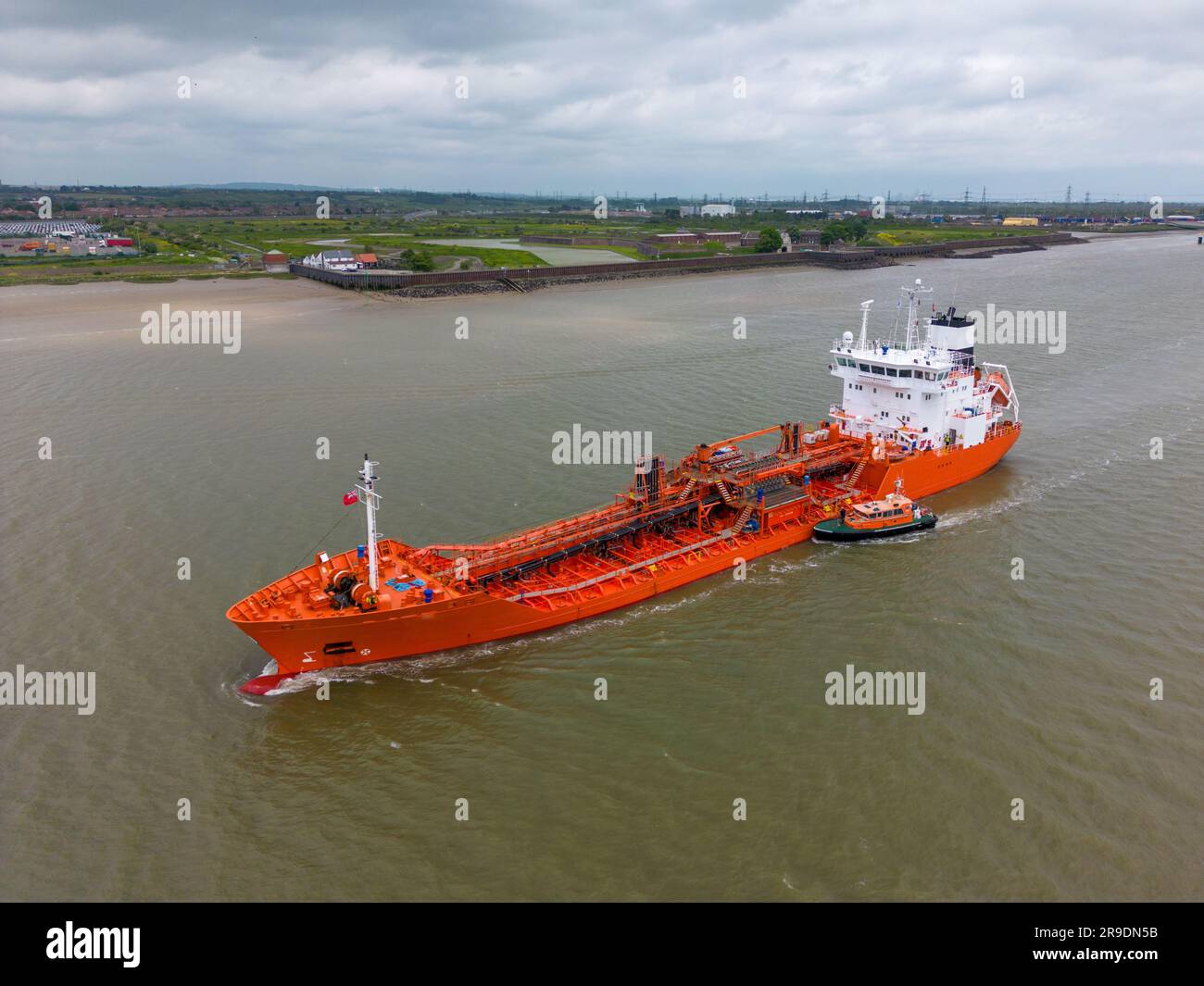 Aerial drone photo of a large freight ship which sails on the river Thames and the Tilbury Docks in England. Stock Photo