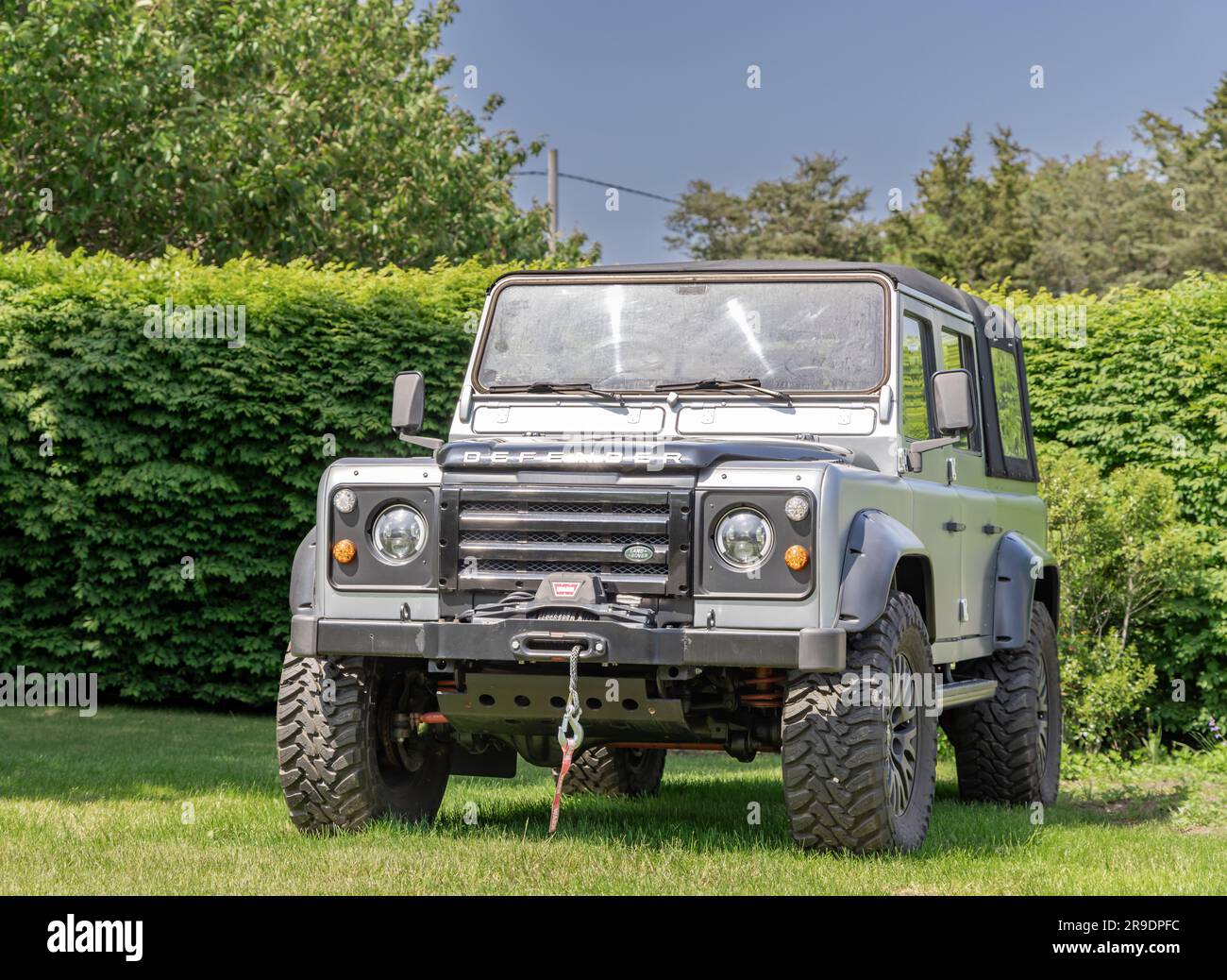 front end of a land rover defender parked in the grass Stock Photo