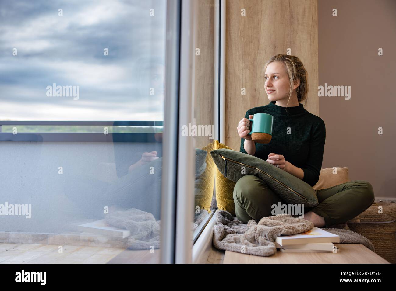 Beautiful girl drinks coffee in a cozy setting. Stock Photo