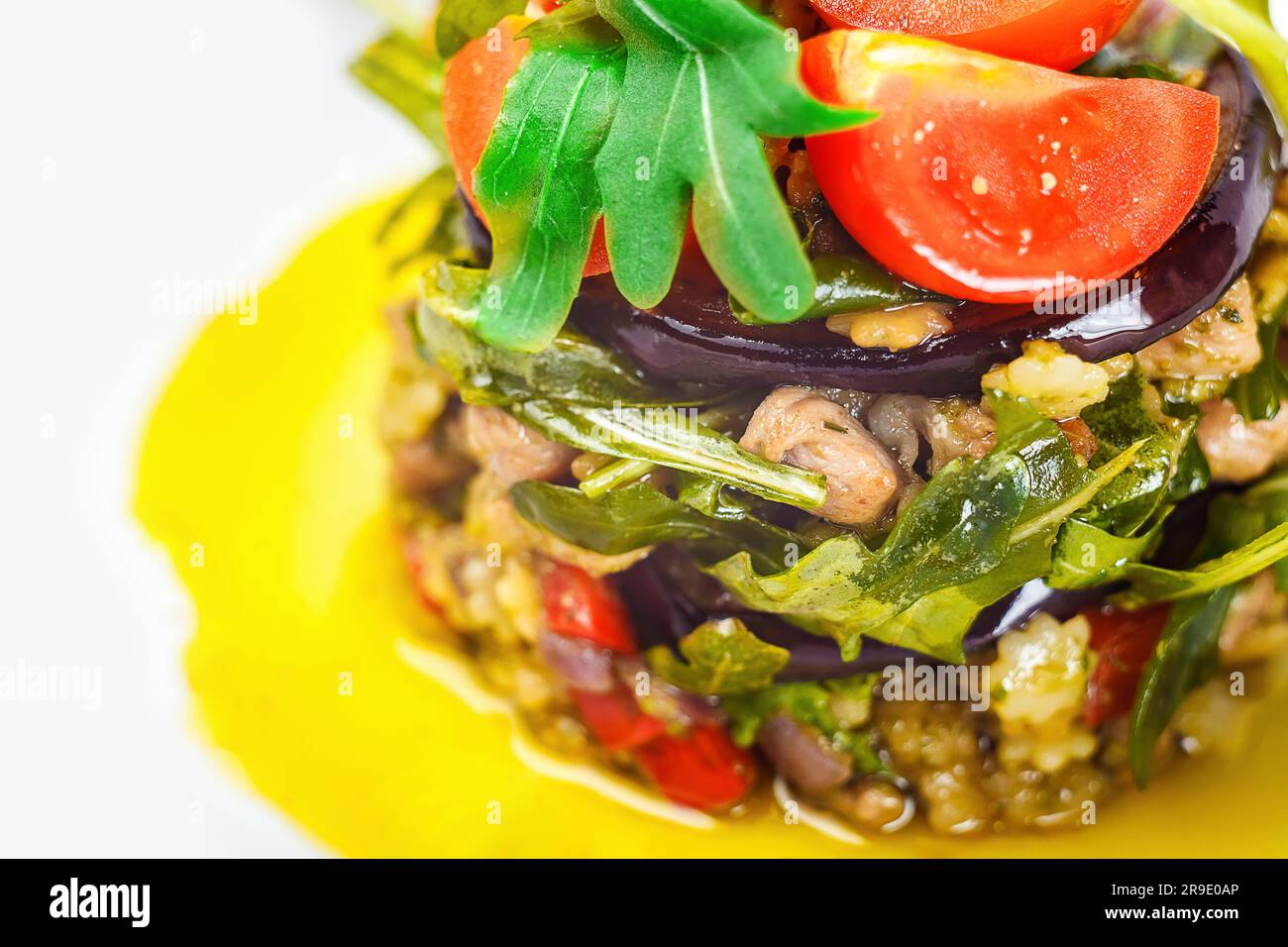 A fresh and vibrant salad with a variety of produce on the plate, including arugula, tomatoes, fruit and vegetables for healthful eating and wellbeing Stock Photo
