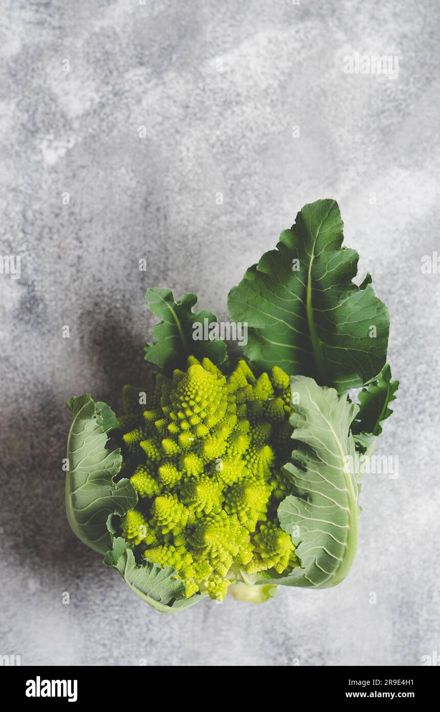 Romanesco broccoli with leaves on grey background with copy space. Stock Photo