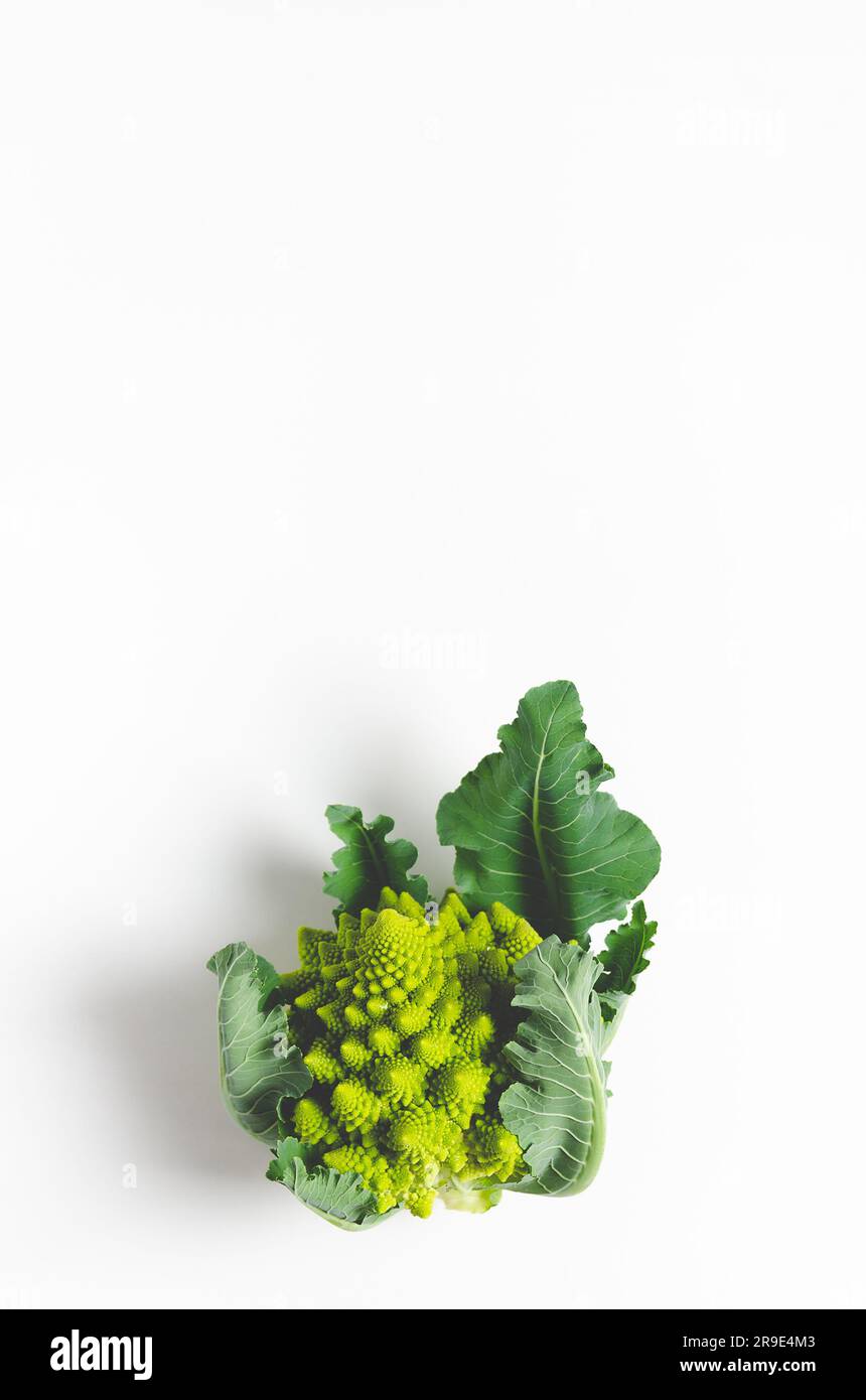 Romanesco broccoli with leaves on white background with copy space. Vertical format. Stock Photo