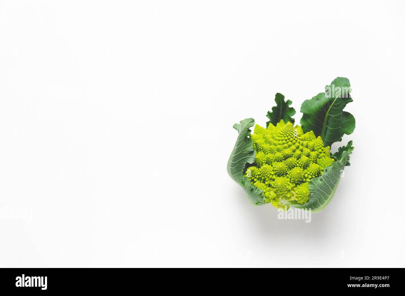 Romanesco broccoli with leaves on white background with copy space. Stock Photo