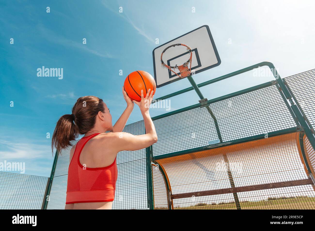 Female basketball player about to throw at the hoop. Outdoors in the