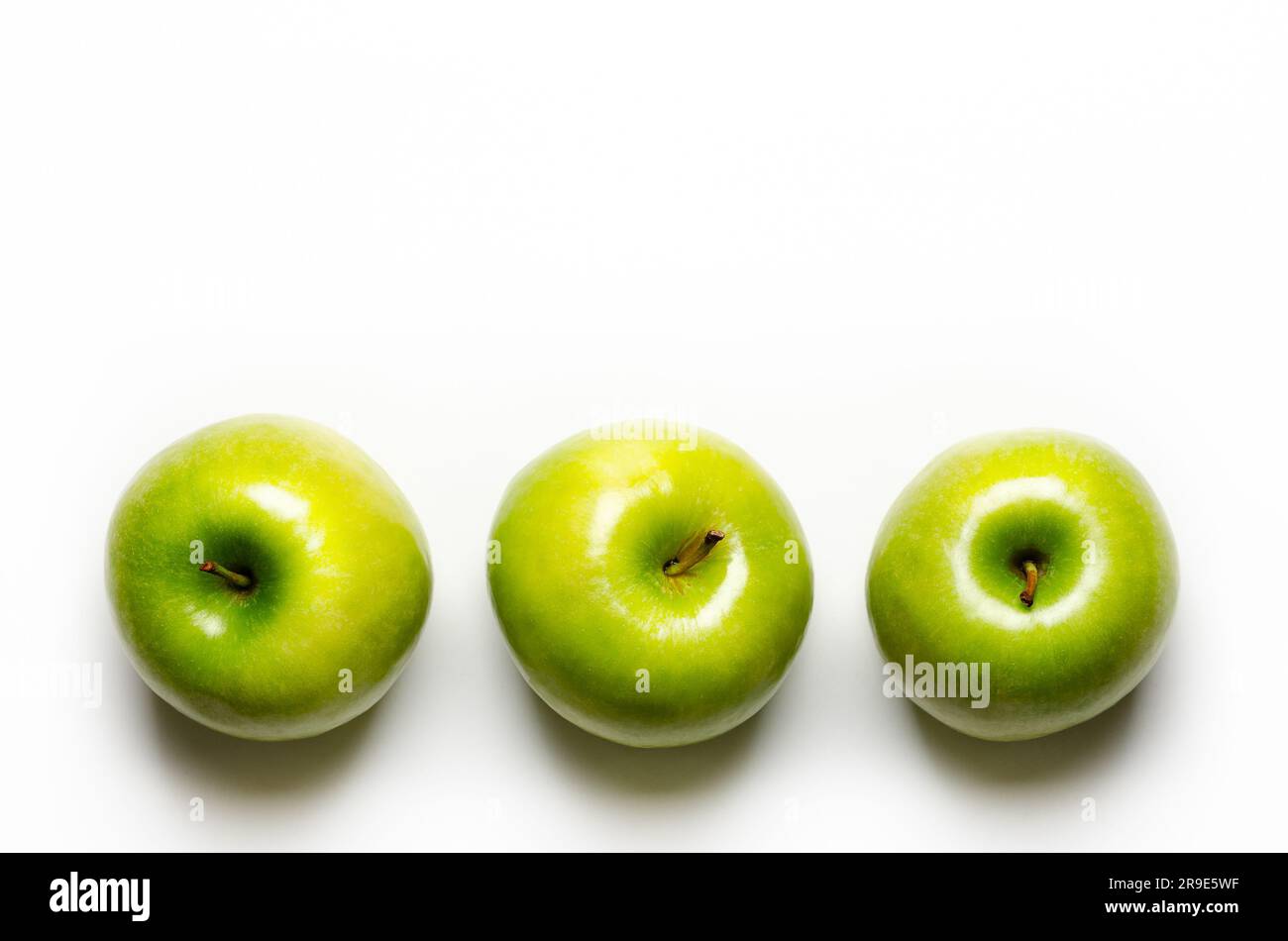 Three green apples on white background with copy space. Stock Photo