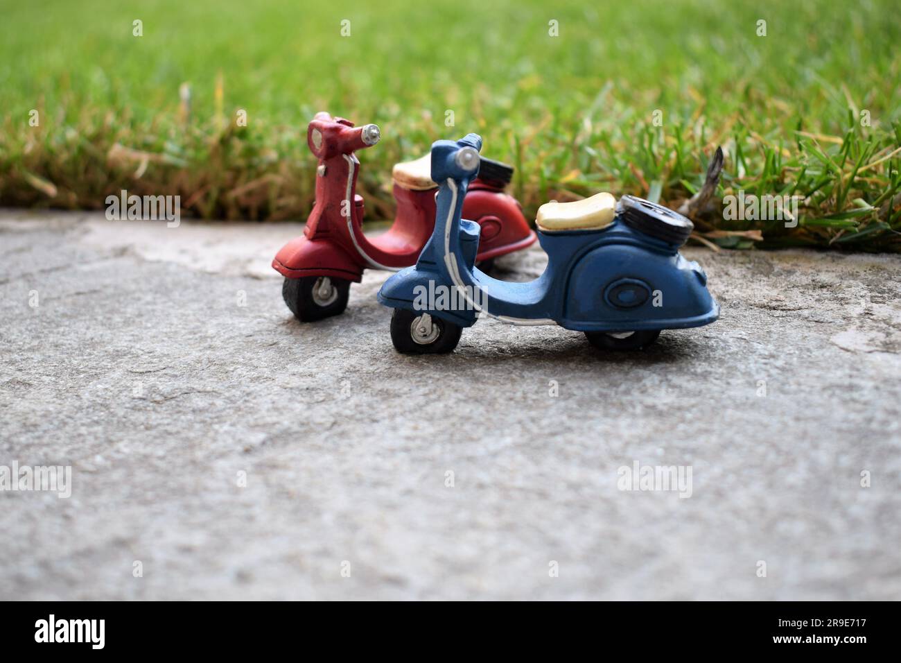 Miniature toy scooters on pavement Stock Photo