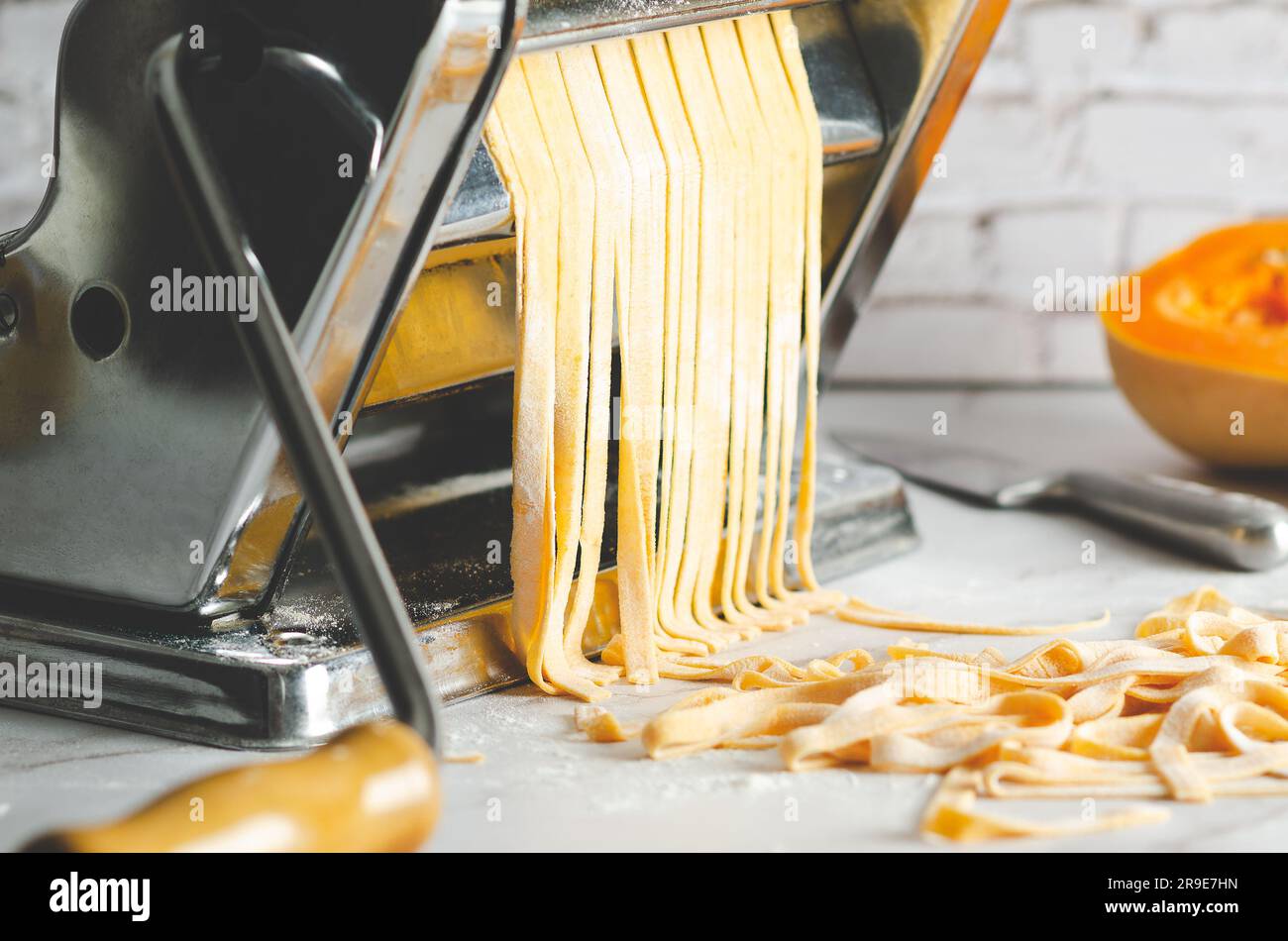 https://c8.alamy.com/comp/2R9E7HN/butternut-squash-noodles-in-a-pasta-maker-machine-a-knife-and-a-piece-of-butternut-squash-on-marble-background-2R9E7HN.jpg
