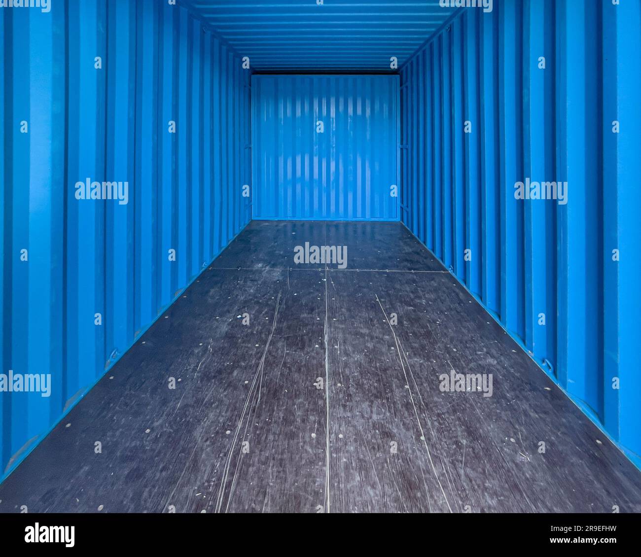 Blue interior of an empty metal shipping container. Shot from the entrance looking inwards Stock Photo