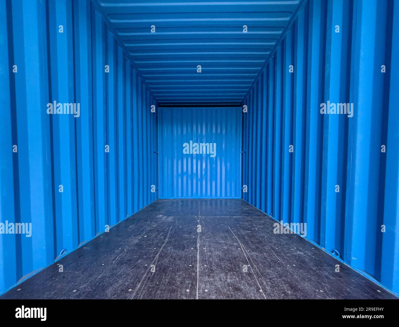 Blue interior of an empty metal shipping container. Shot from the entrance looking inwards Stock Photo