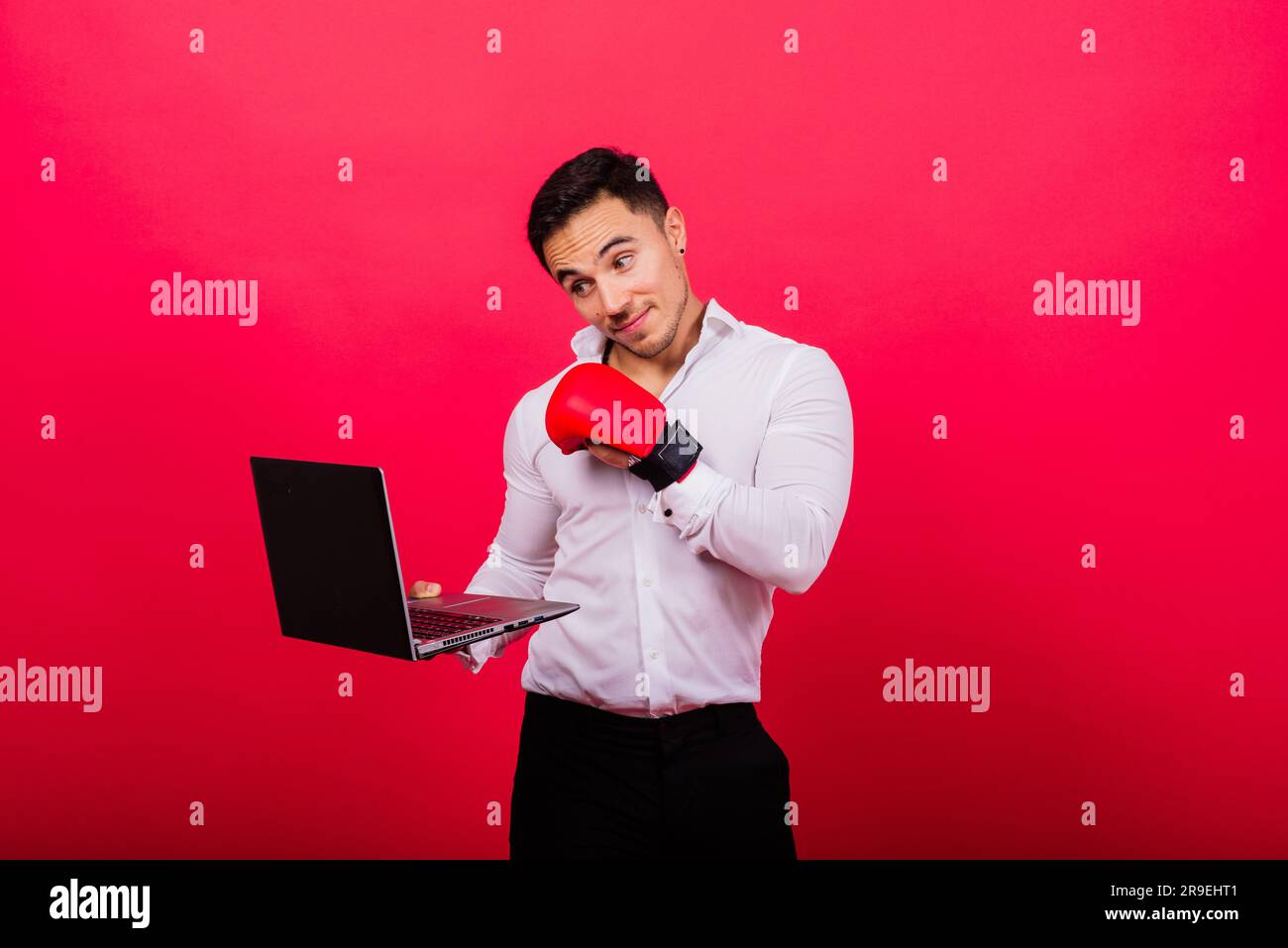 Guy in boxing gloves and formalwear punch computer isolated on red ...