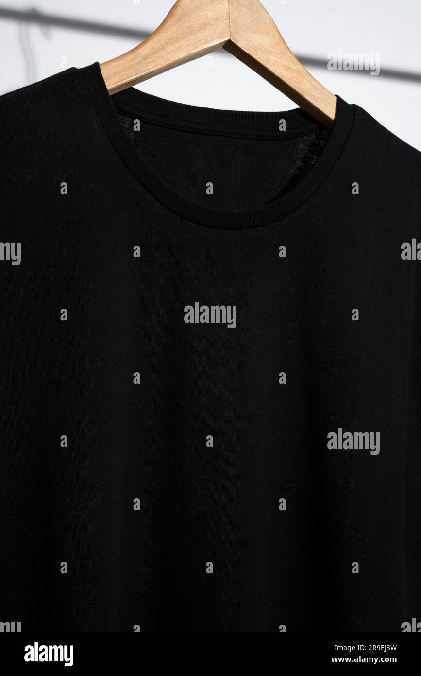 Blank black t-shirt mockup, template on wooden hanger Stock Photo