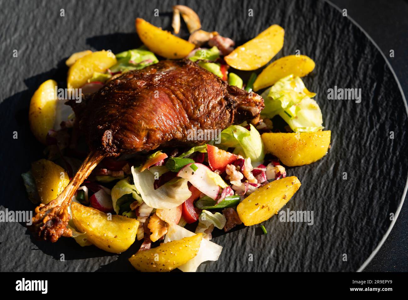 crispy roasted duck legs with salad and potatoes Stock Photo - Alamy