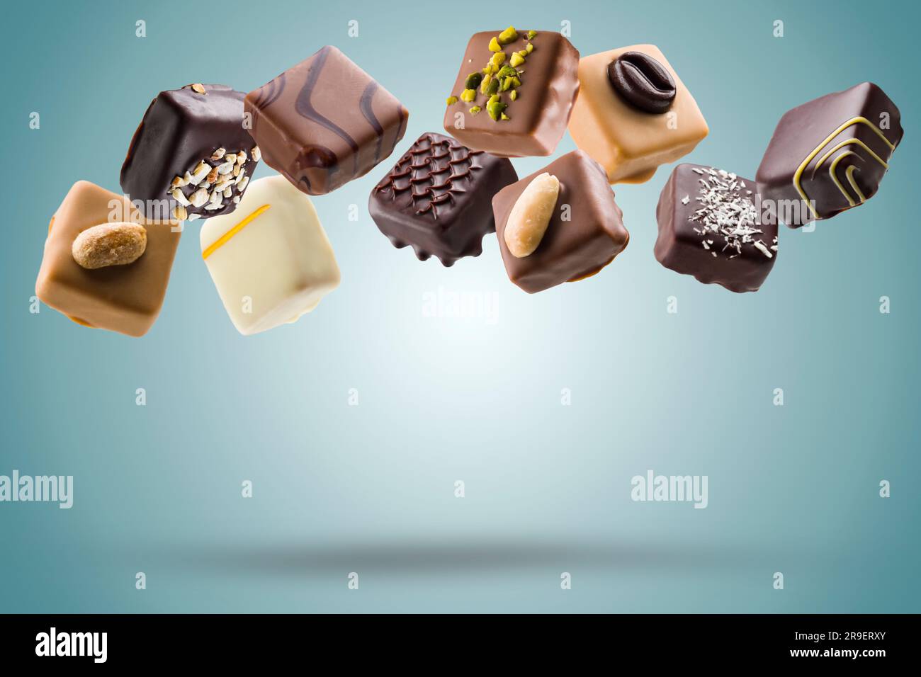 Assorted chocolate pralines floating on blue background Stock Photo