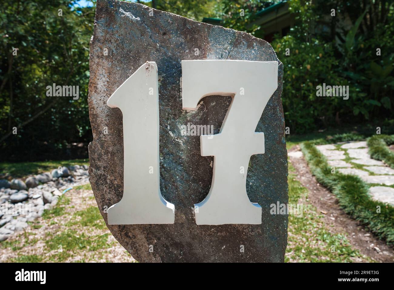 House number 17 installed on a big rock in the garden of residence ...
